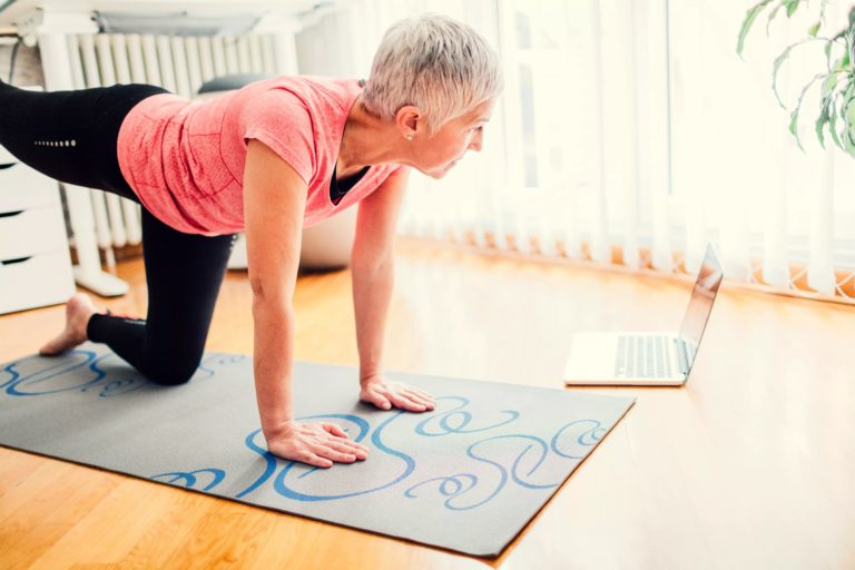 dame som trener på gulvet hjemme med digital coach