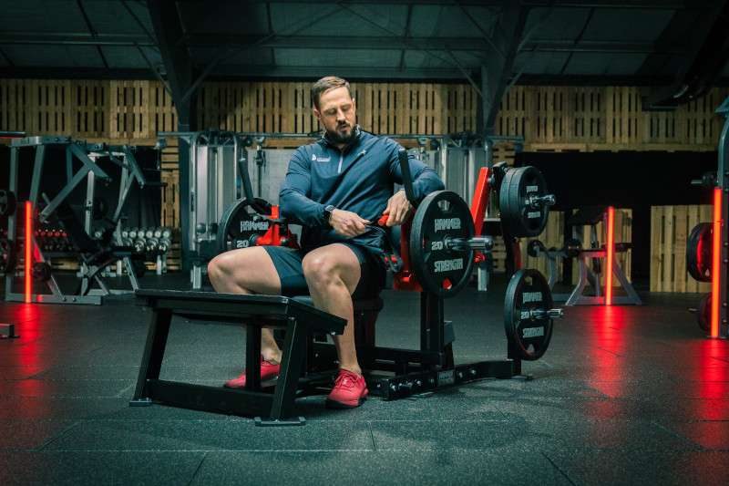 Dedikerad medlem som tränar styrketräning, Hammer Strength Glute Drive